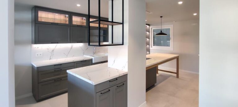 Cocina moderna en color Plomo claro con encimeras Dekton Morpheus, vitrinas iluminadas, vinoteca integrada y mueble colgante metálico y de madera