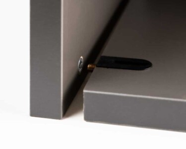 Detalle del armado con tornillo desenroscado de un mueble Senssia en negro Detalle de módulo inferior de cocina en color negro